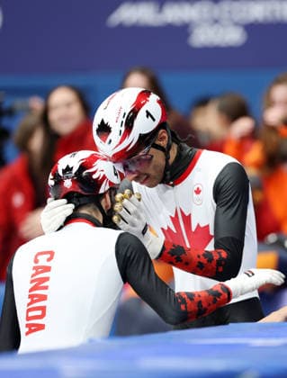 260218 -- MILAN, Feb. 18, 2026 -- Steven Dubois L of Canada celebrates with teammate William Dandjinou after the short track Speed skating, Eisschnelllauf men s 500m final A at the Milan-Cortina 2026 Olympic Winter games, Winterspiele,Spiele, Summer games in Milan, Italy, Feb. 18, 2026. MICO2026ITALY-MILAN-OLYMPIC WINTER GAMES-SHORT TRACK SPEED SKATING-MEN S 500M-FINALS LixMing  (MICO2026)ITALY-MILAN-OLYMPIC WINTER GAMES-SHORT TRACK SPEED SKATING-MEN S 500M-FINALS IMAGO LixMing  imago images 0847989997
