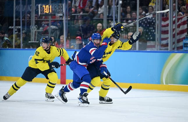 (260219) -- MILAN, Feb. 19, 2026 -- Vincent Trocheck (C) of the United States fights for the puck against Adrian Kempe (R) of Sweden during the Ice hockey, Eishockey men s play-offs quarterfinal between Sweden and the United States at the Milan-Cortina 2026 Olympic Winter games, Winterspiele,Spiele, Summer games in Milan, Italy, Feb. 18, 2026. ) (MICO2026)ITALY-MILAN-OLYMPIC WINTER GAMES-ICE HOCKEY-MEN-PLAY-OFFS QUARTERFINALS-SWE VS USA ZhangxHaofu 
