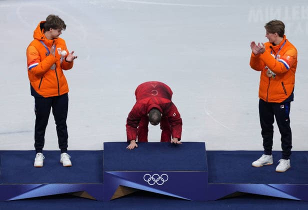 (260219) -- MILAN, Feb. 19, 2026 -- Gold medallist Steven Dubois (C) of Canada touches the podium during the awarding ceremony for the short track Speed skating, Eisschnelllauf men s 500m final A at the Milan-Cortina 2026 Olympic Winter games, Winterspiele,Spiele, Summer games in Milan, Italy, Feb. 18, 2026. ) (MICO2026)ITALY-MILAN-OLYMPIC WINTER GAMES-SHORT TRACK SPEED SKATING-MEN S 500M-FINALS XuexYuge 