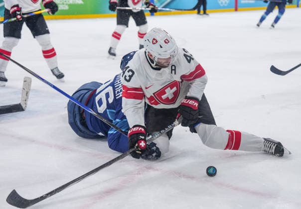 (260219) -- MILAN, Feb. 19, 2026 -- Andrea Glauser (R) of Switzerland vies for the puck during the Ice hockey, Eishockey men s play-offs quarterfinal between Finland and Switzerland at the Milan-Cortina 2026 Olympic Winter games, Winterspiele,Spiele, Summer games in Milan, Italy, Feb. 18, 2026. ) (MICO2026)ITALY-MILAN-OLYMPIC WINTER GAMES-ICE HOCKEY-MEN-PLAY-OFFS QUARTERFINALS-FIN VS SUI SunxFei 