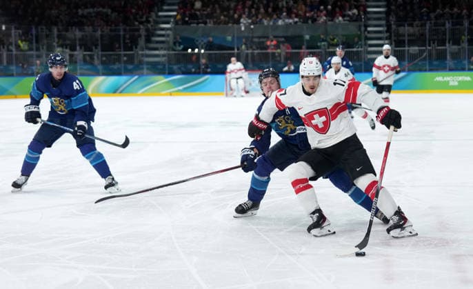 (260219) -- MILAN, Feb. 19, 2026 -- Ken Jager (1st R) of Switzerland vies for the puck during the Ice hockey, Eishockey men s play-offs quarterfinal between Finland and Switzerland at the Milan-Cortina 2026 Olympic Winter games, Winterspiele,Spiele, Summer games in Milan, Italy, Feb. 18, 2026. ) (MICO2026)ITALY-MILAN-OLYMPIC WINTER GAMES-ICE HOCKEY-MEN-PLAY-OFFS QUARTERFINALS-FIN VS SUI SunxFei 