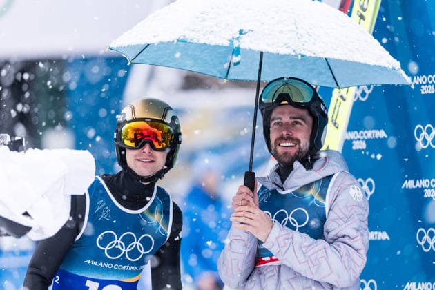 PREDAZZO, ITALY - FEBRUARY 19: Vinzenz Geiger (Germany) and Johannes Rydzek (Germany) in the leaders box, smiling during the Nordic Combined Team Sprint at the Milano Cortina 2026 Olympics at Predazzo Ski jumping, Skispringen, Ski, nordisch Stadium on day 13 of the Milano Cortina 2026 Olympics on February 19, 2026 in Predazzo, Italy. Editorial use only. Italy Copyright: xSteffiexWunderlx