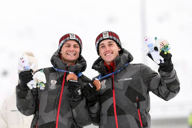 OLYMPICS - Winter Olympic Games, Olympische Spiele, Olympia, OS Milano Cortina 2026 TESERO,ITALY,19.FEB.26 - OLYMPICS, NORDIC SKIING, NORDIC COMBINED - Winter Olympic Games Milano Cortina 2026, team sprint, medal ceremony. Image shows the rejoicing of Johannes Lamparter and Stefan Rettenegger (AUT). Keywords: medaln mascot.  GEPAxpictures xMatthiasxTrinkl
