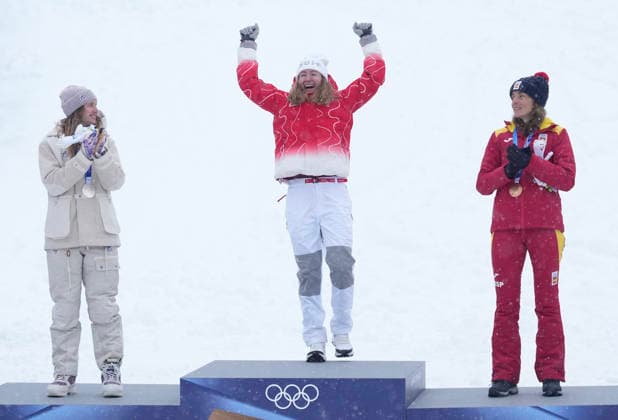 Gold medalist Marianne Fatton of Switzerland (C) celebrates as she is introduced as silver medalist Emily Harrop of France (L) and bronze medalist Ana Alonso Rodriguez of Spain applaud after the Ski Mountaineering Women s Sprint at the Milano Cortina 2026 Winter Olympic Games, Olympische Spiele, Olympia, OS in Bormio, Italy, on Thursday, February 19, 2026.  OLY20260219851 BOBxSTRONG