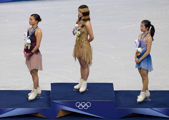 February 19, 2026, Milan, Lombardy, Italy: Team USA figure skater ALYSA LIU on the podium after receiving a gold medal in the Women s Figure skating, Eiskunstlauf Singles Freeskating at the Milano Cortina 2026 Winter Olympics. Japan s KAORI SAKAMOTO (left) won the silver medal and Japan s AMI NAKAI (right) won the bronze. The three listen to the playing of the US national anthem as their country s flags are being raised. Olympics 2026: Milano Cortina: - February 19, 2026  - ZUMAh234 20260219_oly_h234_021 Copyright: xMarkxEdwardxHarrisx