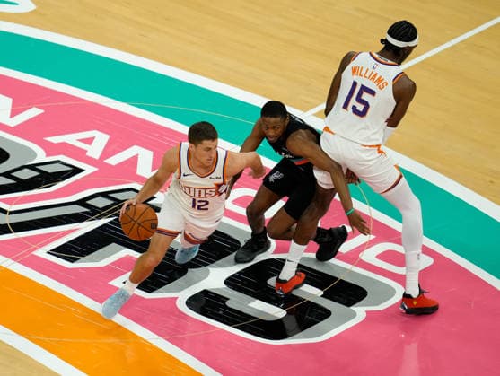 February 19, 2026, Austin, Texas, USA: Phoenix Suns guard COLLIN GILLESPIE (12) moves the ball against San Antonio Spurs guard DE AARON FOX (4) during an NBA, Basketball Herren, USA game between the Spurs and the Suns on February 19, 2026 in Austin, Texas. The Spurs won, 121-94. NBA 2026: Spurs 121: Suns 94  - ZUMAc201 20260219_zap_c201_010 Copyright: xScottxColemanx