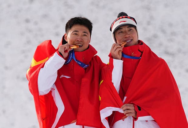 (260220) -- LIVIGNO, Feb. 20, 2026 -- Gold medalist Wang Xindi of China and his teammate Li Tianma pose during the awarding ceremony of the freestyle skiing men s aerials at the Milan-Cortina 2026 Olympic Winter games, Winterspiele,Spiele, Summer games in Livigno, Italy, Feb. 20, 2026. ) (MICO2026)ITALY-LIVIGNO-OLYMPIC WINTER GAMES-FREESTYLE SKIING-MEN S AERIALS-FINAL WuxHuiwo 