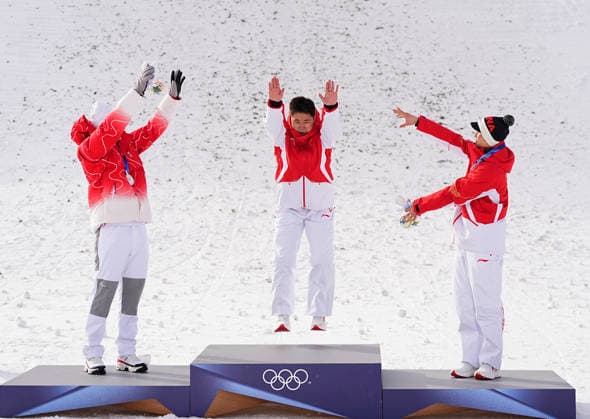 (260220) -- LIVIGNO, Feb. 20, 2026 -- Gold medalist Wang Xindi (C) of China jumps onto the podium during the awarding ceremony of the freestyle skiing men s aerials at the Milan-Cortina 2026 Olympic Winter games, Winterspiele,Spiele, Summer games in Livigno, Italy, Feb. 20, 2026. ) (MICO2026)ITALY-LIVIGNO-OLYMPIC WINTER GAMES-FREESTYLE SKIING-MEN S AERIALS-FINAL WuxHuiwo 