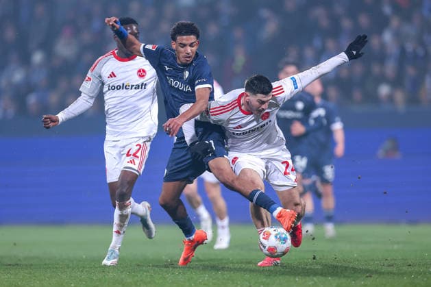 20.02.2026, Fußball, VfL Bochum - 1. FC Nürnberg, 2. Fußball Bundesliga, 23. Spieltag, Vonovia Ruhrstadion, Saison 2025 2026: Francis Onyeka (VfL Bochum 21) im Zweikampf gegen Luka Lochoshvili (1FC Nuernberg 24) neben Rabby Nzingoula (1FC Nuernberg 22) DFB regulations prohibit any use of photographs as image sequences and or quasi-video. Nordrhein-Westfalen Deutschland