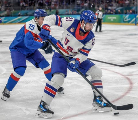 United States Dylan Larkin (21) controls the puck in front of Slovakia s Dalibor Dvorsky (15) in the first period of the Men s Hockey Play-off Semifinal game between Slovakia and the USA at the Milano Santagiulia Ice hockey, Eishockey Arena in Milan, Italy, on Friday, February 20, 2026.  OLY20260220310 AARONxJOSEFCZYK