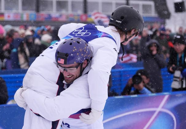 (260221) -- LIVIGNO, Feb. 21, 2026 -- Christopher Lillis of the United States (bottom) hugs his teammate Connor Curran during the freestyle skiing mixed team aerials final 2 at the Milan-Cortina 2026 Olympic Winter games, Winterspiele,Spiele, Summer games in Livigno, Italy, Feb. 21, 2026. ) (MICO2026)ITALY-LIVIGNO-OLYMPIC WINTER GAMES-FREESTYLE SKIING-MIXED TEAM AERIALS-FINAL HuxChao 