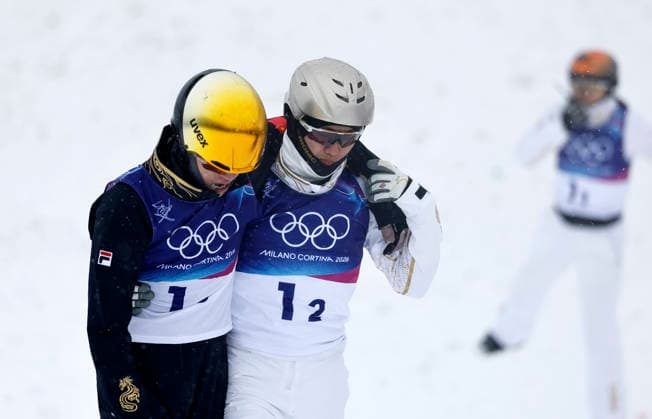 (260221) -- LIVIGNO, Feb. 21, 2026 -- Wang Xindi (C) of China comforts teammate Li Tianma (L) at the freestyle skiing mixed team aerials final 2 at the Milan-Cortina 2026 Olympic Winter games, Winterspiele,Spiele, Summer games in Livigno, Italy, Feb. 21, 2026. ) (MICO2026)ITALY-LIVIGNO-OLYMPIC WINTER GAMES-FREESTYLE SKIING-MIXED TEAM AERIALS-FINAL WangxPeng 