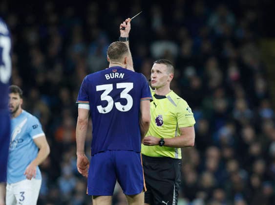 Manchester, England, 21st February 2026. Referee Thomas Bramall issues a yellow card to Dan Burn of Newcastle United during the Manchester City vs Newcastle United Premier League match at the Etihad Stadium, Manchester. Picture credit should read: Cody Froggatt Sportimage EDITORIAL USE ONLY. No use with unauthorised audio, video, data, fixture lists, club league logos or live services. Online in-match use limited to 120 images, no video emulation. No use in betting, games or single club league player publications. SPI_016_CF_Man_City_Newc SPI-4542-0016