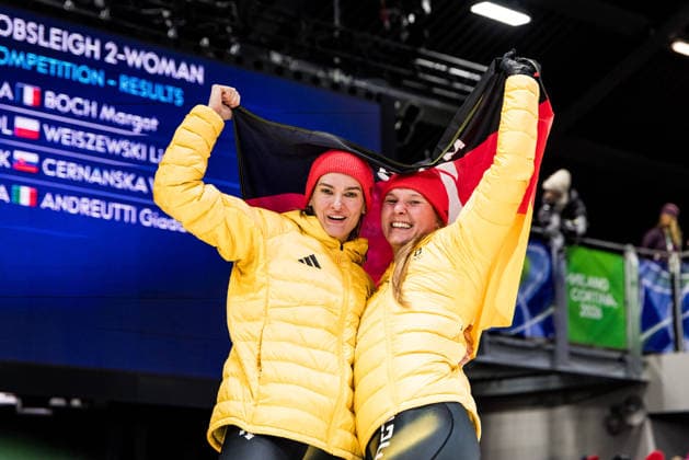 CORTINA, ITALY - FEBRUARY 21: Lisa Buckwitz Neele Schuten (Germany) cheer with a flag during the Bobsleigh 2-woman Heat 3 and 4 at the Milano Cortina 2026 Olympics at Cortina Sliding Centre on day 15 of the Milano Cortina 2026 Olympics on February 21, 2026 in Cortina, Italy. Editorial use only. Italy Copyright: xSteffiexWunderlx
