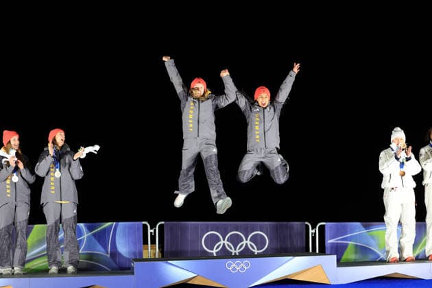 (260222) -- CORTINA D AMPEZZO, Feb. 22, 2026 -- Gold medalists Laura Nolte (3rd L) Deborah Levi (2nd R) of Germany jump on the podium during the awarding ceremony for the Bobsleigh 2-woman at the 2026 Milan-Cortina Winter Olympics in Cortina, Italy, Feb. 21, 2026. ) (MICO2026)ITALY-CORTINA D AMPEZZO-OLYMPIC Winter games, Winterspiele,Spiele, Summer games BOBSLEIGH-2-WOMAN DingxXu 