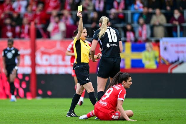 Riem Hussein (Schiedsrichterin, Referee) zeiogt Camilla Kuever (Wolfsburg, 16) die Gelbe Karte, Verwarnung, yellow card, 22.02.2026, München (Deutschland), Fussball, Google Pixel Frauen-Bundesliga, FC Bayern München - VfL Wolfsburg, DFB DFL REGULATIONS PROHIBIT ANY USE OF PHOTOGRAPHS AS IMAGE SEQUENCES AND OR QUASI-VIDEO.