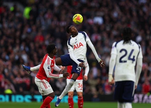 22nd February 2026; Tottenham Hotspur Stadium, London, England; Premier League Football, Tottenham Hotspur versus Arsenal; Pape Matar Sarr of Tottenham Hotspur heads the ball over Bukayo Saka of Arsenal  JPxFletcher Content restricted for UK based newspaper