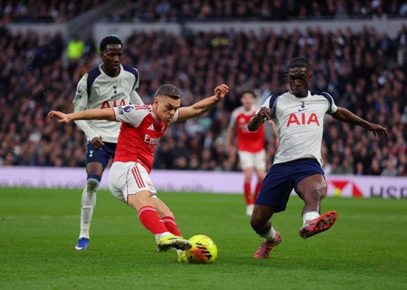 22nd February 2026; Tottenham Hotspur Stadium, London, England; Premier League Football, Tottenham Hotspur versus Arsenal; Leandro Trossard of Arsenal takes a shot on goal past Yves Bissouma of Tottenham Hotspur  JPxFletcher Content restricted for UK based newspaper