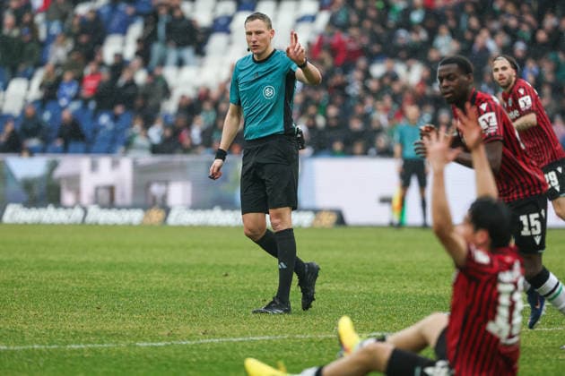 2. Bundesliga - Hannover 96 - Dynamo Dresden am 22.02.2026 in der Heinz von Heiden Arena in Hannover Schiedsrichter Martin Petersen gestikuliert , Spieler Daisuke Yokota (Hannover) sitzt im Vordergrund auf dem Rasen