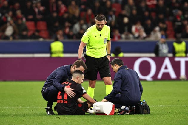 GER, Champions League, Bayer Leverkusen vs Olympiakos Piräus 24.02.2026, BayArena, Leverkusen, GER, Champions League, Bayer Leverkusen vs Olympiakos Piräus im Bild Lucas Vazquez (Bayer 04 Leverkusen, 21, schwarz) muss verletzungsbedingt den Platz verlassen, Schiedsrichter Michael Oliver (England) erkundigt sich über den Gesundheitszustand