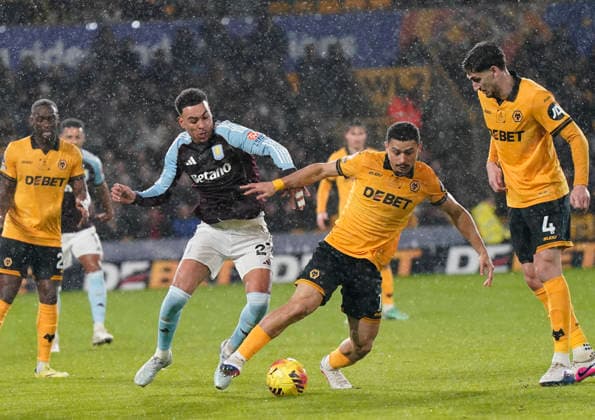 Wolverhampton, England, 27th February 2026. Morgan Rogers of Aston Villa tackles Andre of Wolverhampton Wanderers during the Wolverhampton Wanderers vs Aston Villa Premier League match at Molineux, Wolverhampton. Picture credit should read: Andrew Yates Sportimage EDITORIAL USE ONLY. No use with unauthorised audio, video, data, fixture lists, club league logos or live services. Online in-match use limited to 120 images, no video emulation. No use in betting, games or single club league player publications. SPI_024_AY_Wolves_Villa SPI-4564-0024