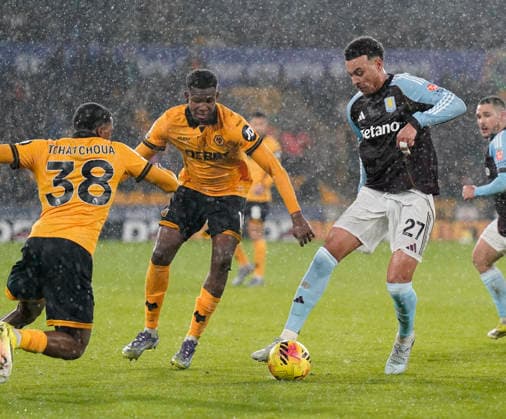 Wolverhampton, England, 27th February 2026. Morgan Rogers of Aston Villa attempts get past Jackson Tchatchoua of Wolverhampton Wanderers and Yerson Mosquera of Wolverhampton Wanderers during the Wolverhampton Wanderers vs Aston Villa Premier League match at Molineux, Wolverhampton. Picture credit should read: Andrew Yates Sportimage EDITORIAL USE ONLY. No use with unauthorised audio, video, data, fixture lists, club league logos or live services. Online in-match use limited to 120 images, no video emulation. No use in betting, games or single club league player publications. SPI_026_AY_Wolves_Villa SPI-4564-0026