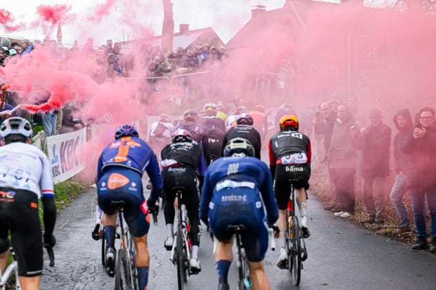 Omloop Het Nieuwsblad 2026 Cycling Race NINOVE, BELGIUM - FEBRUARY 28 : Illustration picture of the peloton riding through red smoke flare during the 81th edition of Omloop Het Nieuwsblad an UCI World Tour 1.UWT one day cycling road race for Men Elite of km with start in Ghent and finish in Ninove on February 28, 2026 in Ninove, Belgium, 28 02 2026 ( Motordriver Kenny Verfaillie - Ninove Belgium  Copyright: xNicoxVereeckenx