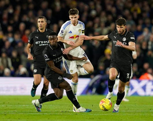 Leeds, England, 28th February 2026. Anton Stach of Leeds United (c) pushes past Marc Guehi of Manchester City (l) and Ruben Dias of Manchester City (r) during the Leeds United vs Manchester City Premier League match at Elland Road, Leeds. Picture credit should read: Andrew Yates Sportimage EDITORIAL USE ONLY. No use with unauthorised audio, video, data, fixture lists, club league logos or live services. Online in-match use limited to 120 images, no video emulation. No use in betting, games or single club league player publications. SPI_057_AY_Leeds_Man_City SPI-4565-0057