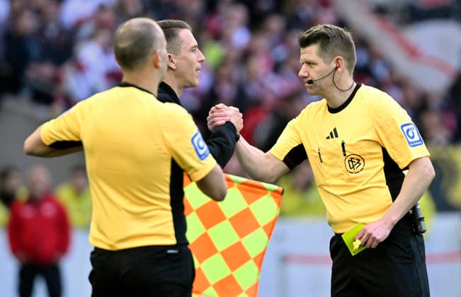 Schiedsrichter Referee Patrick Ittrich zeigt Trainer Coach Daniel Bauer VfL Wolfsburg gelbe Karte gelb Verwarnung und schuettelt ihm danach die Hand Gestik Geste VfB Stuttgart vs VfL Wolfsburg WOB 01.03.2026 DFL REGULATIONS PROHIBIT ANY USE OF PHOTOGRAPHS AS IMAGE SEQUENCES AND OR QUASI-VIDEO VfB Stuttgart vs VfL Wolfsburg WOB