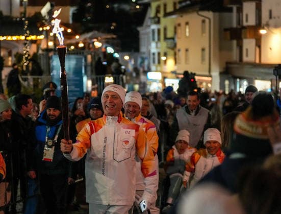 (260304) -- CORTINA D AMPEZZO, March 4, 2026 -- A torchbearer carrys the torch during the Milan-Cortina 2026 Paralympic Winter games, Winterspiele,Spiele, Summer games Torch Relay and Flame Unifying Ceremony in Cortina D Ampezzo, Italy, March 3, 2026. ) (SP)ITALY-CORTINA D AMPEZZO-PARALYMPIC WINTER GAMES-FLAME UNIFYING CEREMONY LianxZhen 