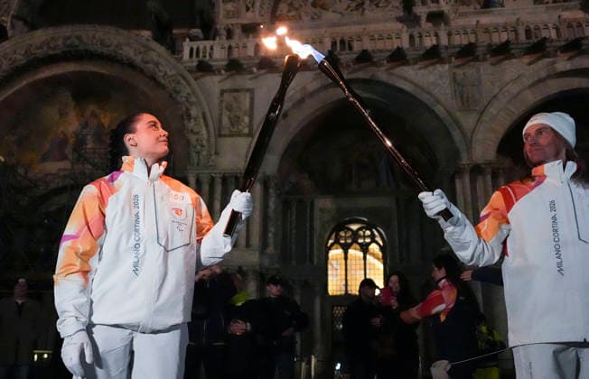 (260305) -- VENICE, March 5, 2026 -- Torchbearers Alfreider Peter (R) and Matilde Villa pass the flame during the Milan-Cortina 2026 Paralympic Winter games, Winterspiele,Spiele, Summer games Torch Relay in Venice, Italy, March 4, 2026. ) (SP)ITALY-VENICE-PARALYMPIC WINTER GAMES-TORCH RELAY HouxJun 