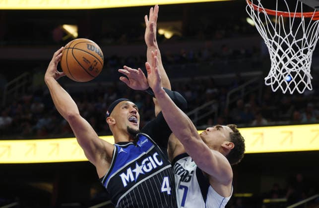 March 5, 2026, Orlando, Florida, USA: Orlando Magic guard JALEN SUGGS (4) tries to shoot past Dallas Mavericks center DWIGHT POWELL (7) during the NBA, Basketball Herren, USA game at the Kia Center on Thursday in Orlando. Orlando USA - ZUMAm67_ 20260305_zaf_m67_012 Copyright: xStephenxM.xDowellx