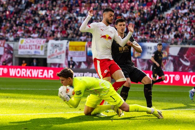 GER, Bundesliga, RB Leipzig - FC Augsburg. 07.03.2026, Red Bull Arena, Leipzig, GER, Bundesliga, RB Leipzig - FC Augsburg. Finn Dahmen (FC Augsburg 1) Kart gegen Romulo Cardoso (RB Leipzig 40) Â