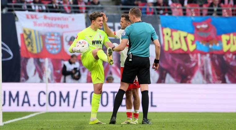 RB Leipzig - Augsburg Bundesliga Leipzig, 07.03.2026, Red Bull Arena, Fußball, 1.Bundesliga, 25.Spieltag , RB Leipzig vs. FC Augsburg , Im Bild von links: Torwart Finn Dahmen ( 1,Augsburg), Christoph Baumgartner (14, RB Leipzig), Schiedsrichter Martin Petersen, , Nur zur redaktionellen Nutzung. Only editorial use. , DFL DFB regulations prohibit any use of photographs as image sequences and or quasi-video. ,