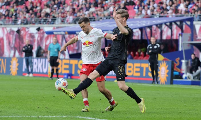 Christoph Baumgartner am Ball, Anton Kade Zweikampf Spielszene Aktion Fußball Fussball DFL Bundesliga Herren 25. Spieltag Saison 2025 2026 07.03.2026 RasenBallsport RB Leipzig RBL vs. FC Augsburg FCA in der RedBull Arena DFL regulations prohibit any use of photographs as image sequences and or quasi-video.