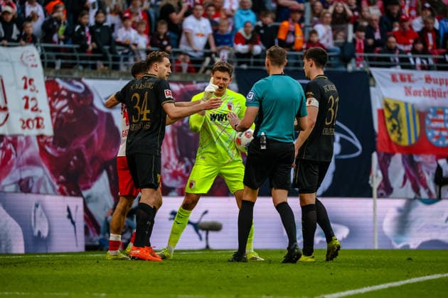 Finn Dahmen (FC Augsburg, 01) beschwert sich bei Martin Petersen (Schiedsrichter, DFB) ueber Christoph Baumgartner (RB Leipzig, 14), Arthur Chaves (FC Augsburg, 34), Keven Schlotterbeck (FC Augsburg, 31), RB Leipzig vs. FC Augsburg, Fussball, 1. Bundesliga, 25. Spieltag, Saison 2025 2026, 07.03.2026,¨ DFL REGULATIONS PROHIBIT ANY USE OF PHOTOGRAPHS AS IMAGE SEQUENCES AND OR QUASI-VIDEO,¨ RB Leipzig vs. FC Augsburg, Fussball, 1. Bundesliga, 25. Spieltag, Saison 2025 2026, 07.03.2026 Leipzig