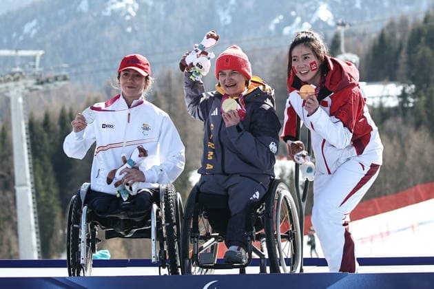 ITALY, VENETO - MARCH 7, 2026: Silver medallist Audrey Pascual Seco of Spain, gold medal winner Anna-Lena Forster and bronze medallist Sitong Liu of China (L-R) celebrate during the victory ceremony for the women s para alpine skiing downhill sit-skiing event at the 2026 Winter Paralympic Games on the Olympia delle Tofane of the Tofane Alpine Skiing Centre in Cortina d Ampezzo, Province of Belluno. Mikhail Tereshchenko TASS  89702948