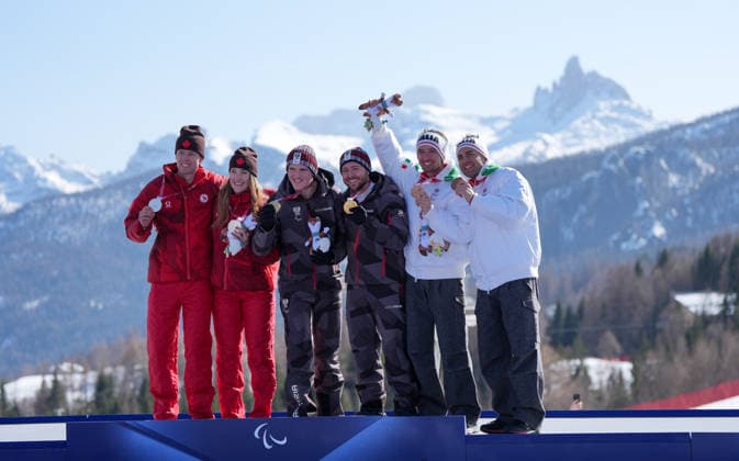 (260308) -- CORTINA D AMPEZZO, March 8, 2026 -- Gold medalist Johannes Aigner (3rd L) of Austria, silver medalist Kalle Ericsson (1st L) of Canada, bronze medalist Giacomo Bertagnolli (2nd R) of Italy pose with their guides during the awarding ceremony for the para alpine skiing men s downhill vision impaired match at the Milan-Cortina 2026 Paralympic Winter games, Winterspiele,Spiele, Summer games in Cortina D ampezzo, Italy, March 7, 2026. ) (SP)ITALY-CORTINA D AMPEZZO-PARALYMPIC WINTER GAMES-PARA ALPINE SKIING-MEN S DOWNHILL-VISION IMPAIRED WangxKaiyan 