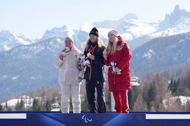 (260308) -- CORTINA D AMPEZZO, March 8, 2026 -- Gold medalist Ebba Aarsjoe (C) of Sweden, silver medalist Aurelie Richard (L) of France and bronze medalist Varvara Voronchikhina of Russia react during the awarding ceremony after the para alpine skiing women s downhill standing match at the Milan-Cortina 2026 Paralympic Winter games, Winterspiele,Spiele, Summer games in Cortina D ampezzo, Italy, March 7, 2026. ) (SP)ITALY-CORTINA D AMPEZZO-PARALYMPIC WINTER GAMES-PARA ALPINE SKIING-WOMEN S DOWNHILL STANDING WangxKaiyan 