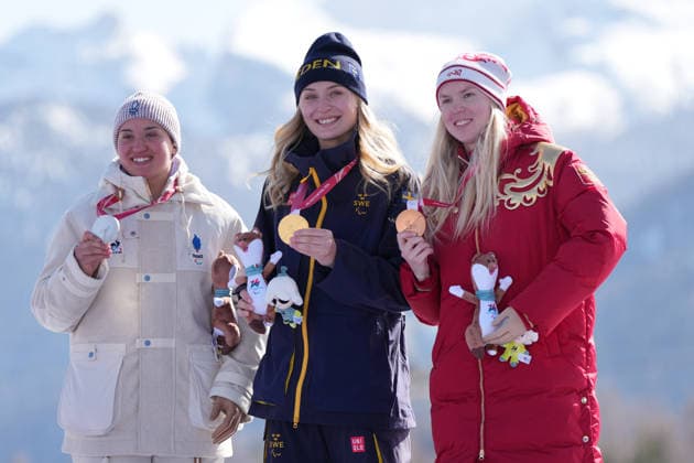 (260308) -- CORTINA D AMPEZZO, March 8, 2026 -- Gold medalist Ebba Aarsjoe (C) of Sweden, silver medalist Aurelie Richard (L) of France and bronze medalist Varvara Voronchikhina of Russia react during the awarding ceremony after the para alpine skiing women s downhill standing match at the Milan-Cortina 2026 Paralympic Winter games, Winterspiele,Spiele, Summer games in Cortina D ampezzo, Italy, March 7, 2026. ) (SP)ITALY-CORTINA D AMPEZZO-PARALYMPIC WINTER GAMES-PARA ALPINE SKIING-WOMEN S DOWNHILL STANDING WangxKaiyan 