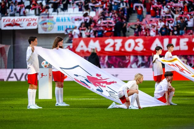 Kinder halten die Fahnen mit Verinslogo beim Einlaufen, RB Leipzig vs. FC Augsburg, Fussball, 1. Bundesliga, 25. Spieltag, Saison 2025 2026, 07.03.2026,¨ DFL REGULATIONS PROHIBIT ANY USE OF PHOTOGRAPHS AS IMAGE SEQUENCES AND OR QUASI-VIDEO,¨ RB Leipzig vs. FC Augsburg, Fussball, 1. Bundesliga, 25. Spieltag, Saison 2025 2026, 07.03.2026 Leipzig