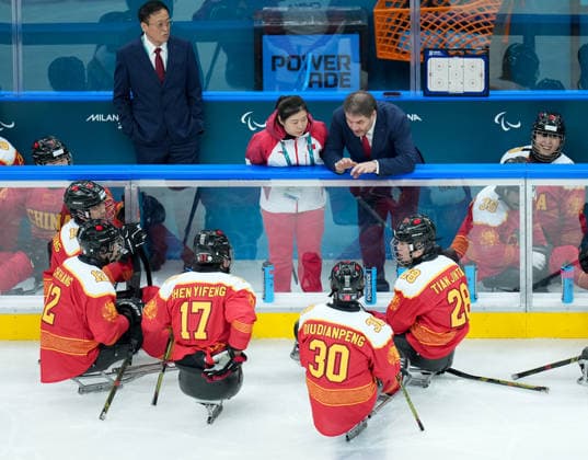 (260308) -- MILAN, March 8, 2026 -- China s head coach Nikolay Sharshukov (top R) instructs from the sidelines during the Para Ice hockey, Eishockey preliminary round Group A match between China and Germany at the Milan-Cortina 2026 Paralympic Winter games, Winterspiele,Spiele, Summer games in Milan, Italy, March 7, 2026. ) (SP)ITALY-MILAN-PARALYMPIC WINTER GAMES-PARA ICE HOCKEY-CHINA VS GERMANY LixJing 