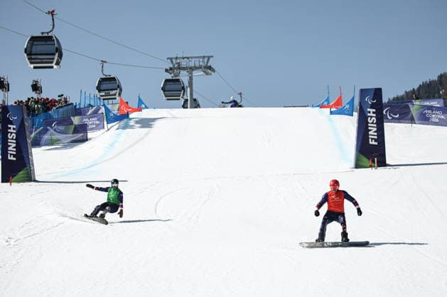 ITALY, VENETO - MARCH 8, 2026: Noah Elliott (L) and Mike Schultz of the US compete during the men s para snowboard snowboard cross SB-LL1 event at Cortina Para Snowboard Park during the 2026 Winter Paralympic Games. Mikhail Tereshchenko TASS  89753197