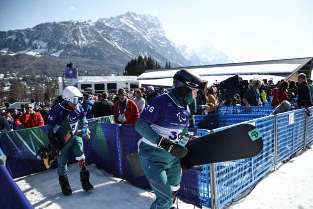 ITALY, VENETO - MARCH 8, 2026: Dmitry Fadeyev (L) and Filipp Shebbo of Russia competes during the men s para snowboard snowboard cross SB-LL1 event at Cortina Para Snowboard Park during the 2026 Winter Paralympic Games. Mikhail Tereshchenko TASS  89753471