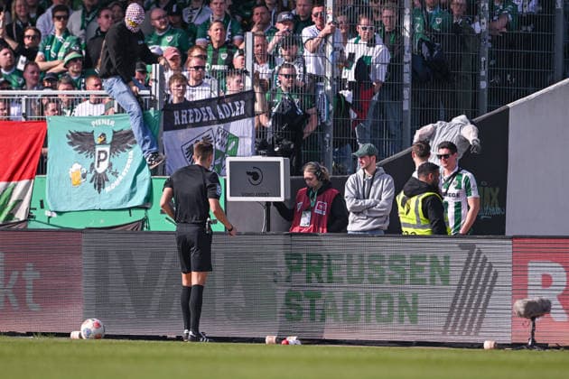 08.03.2026, Fussball, 2. Bundesliga, 25. Spieltag Saison 2025 2026, Preußen Münster - Hertha BSC, Zwei Vermummte springen über die Bande als sich Schiedsrichter Felix Bickel die Szene ansehen will, xRHR-FOTO TKx