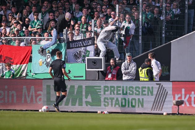 08.03.2026, Fussball, 2. Bundesliga, 25. Spieltag Saison 2025 2026, Preußen Münster - Hertha BSC, Zwei Vermummte springen über die Bande als sich Schiedsrichter Felix Bickel die Szene ansehen will, xRHR-FOTO TKx