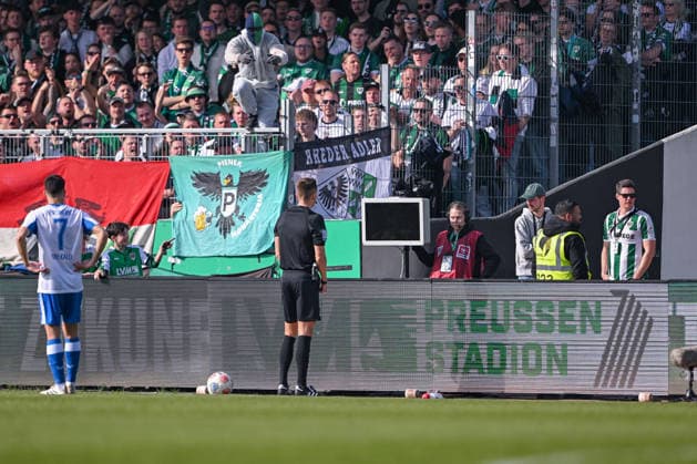 08.03.2026, Fussball, 2. Bundesliga, 25. Spieltag Saison 2025 2026, Preußen Münster - Hertha BSC, Zwei Vermummte springen über die Bande als sich Schiedsrichter Felix Bickel die Szene ansehen will, xRHR-FOTO TKx