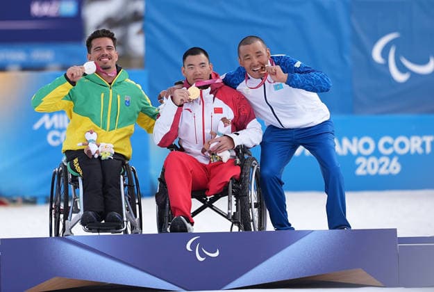 (260311) -- TESERO, March 11, 2026 -- Gold medalist Liu Zixu (C) of China poses on the podium alongside silver medalist Cristian Westemaier Ribera (L) of Brazil and bronze medalist Yerbol Khamitov of Kazakhstan after the final of the Para Cross-Country Skiing men s Sprint Sitting event at the Milan-Cortina 2026 Paralympic Winter games, Winterspiele,Spiele, Summer games in Tesero, Italy, March 10, 2026. ) (SP)ITALY-TESERO-PARALYMPIC WINTER GAMES-PARA CROSS-COUNTRY-MEN S SPRINT SITTING HouxZhaokang 
