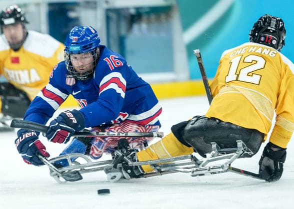 (260311) -- MILAN, March 11, 2026 -- Declan Farmer (L) of the United States vies with Che Hang of China during the Para Ice hockey, Eishockey preliminary round match of Group A between the United States and China at the Milan-Cortina 2026 Paralympic Winter games, Winterspiele,Spiele, Summer games in Milan, Italy, March 10, 2026. ) (SP)ITALY-MILAN-PARALYMPIC WINTER GAMES-PARA ICE HOCKEY-USA VS CHINA LixJing 
