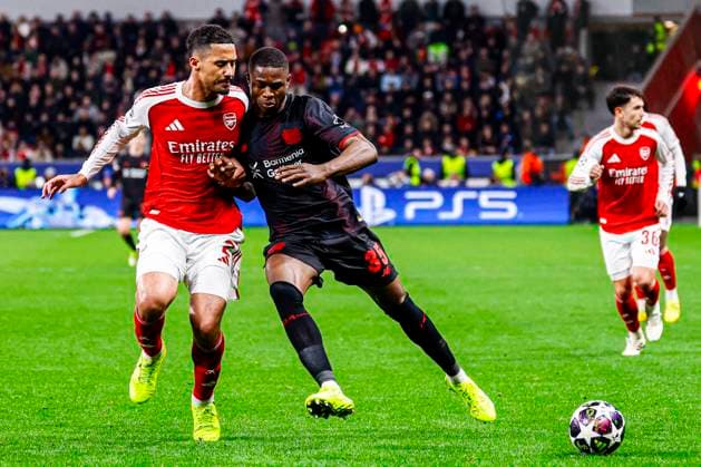 Christian Kofane of Bayer 04 Leverkusen battles for possession with William Saliba of Arsenal FC Bayer 04 Leverkusen v Arsenal FC, UEFA Champions League 2025 26 Round of 16 First Leg, Bayer 04 Leverkusen v Arsenal FC, BayArena, March 11, 2026, Leverkusen, Germany.